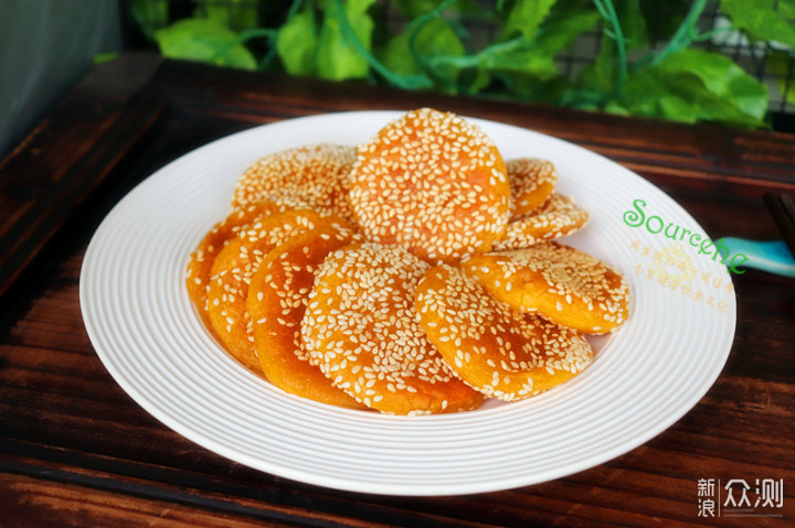 南瓜饼不加芝麻就缺少香味了,揉搓好的南瓜饼,放入芝麻的碗里,均匀沾