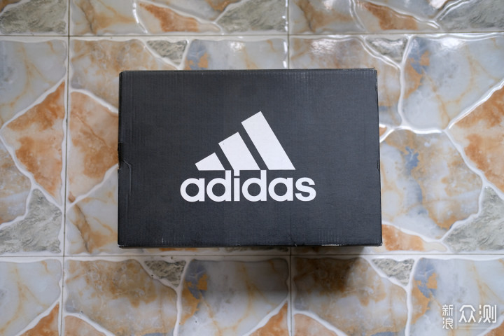 鞋子的包装盒为黑色,上盖的正面有adidas的logo标识,整个盒子的装束